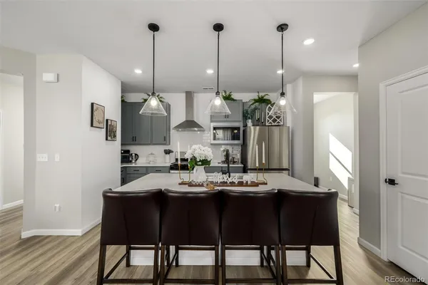 a kitchen with stainless steel appliances kitchen island granite countertop a table chairs and a wooden floor