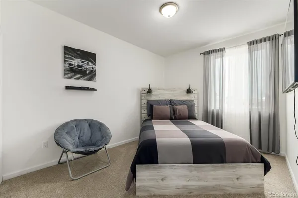 a bedroom with a bed a table and chair