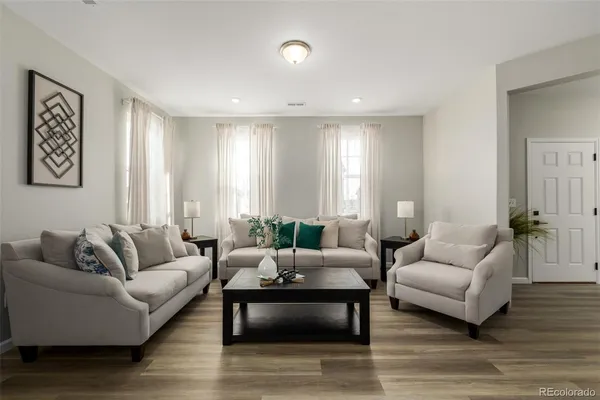 a living room with furniture and wooden floor