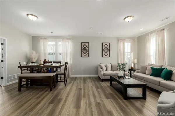 a living room with furniture and a wooden floor