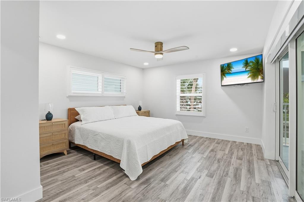 270 Dundee Road Fort Myers Beach, FL 33931 - Photo 20 of 48 Bedroom with access to outside, ceiling fan, light wood-style flooring, and recessed lighting - Virtually Edited Image