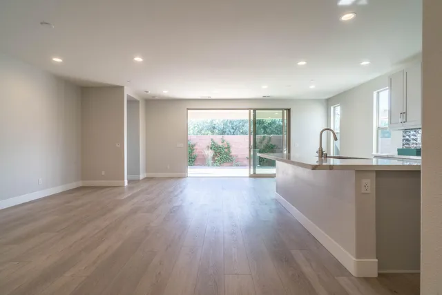 a view of a kitchen with wooden floor and outdoor space