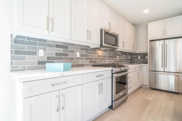 a large kitchen with stainless steel appliances kitchen island granite countertop a sink and cabinets