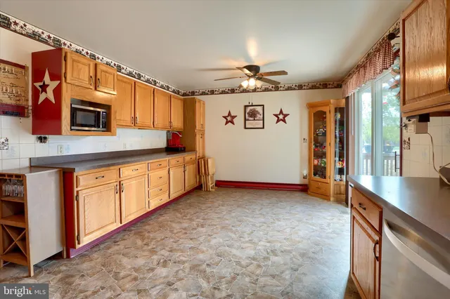 a view of a kitchen with stainless steel appliances granite countertop a sink and cabinets