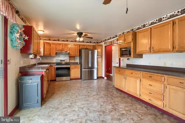 a kitchen with stainless steel appliances granite countertop a stove a sink and a refrigerator