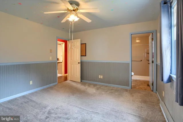 an empty room with closet and fan
