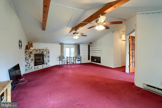 a view of empty room with fireplace and window