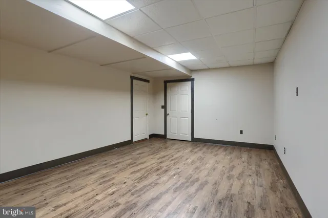 a view of a room with wooden floors and white walls