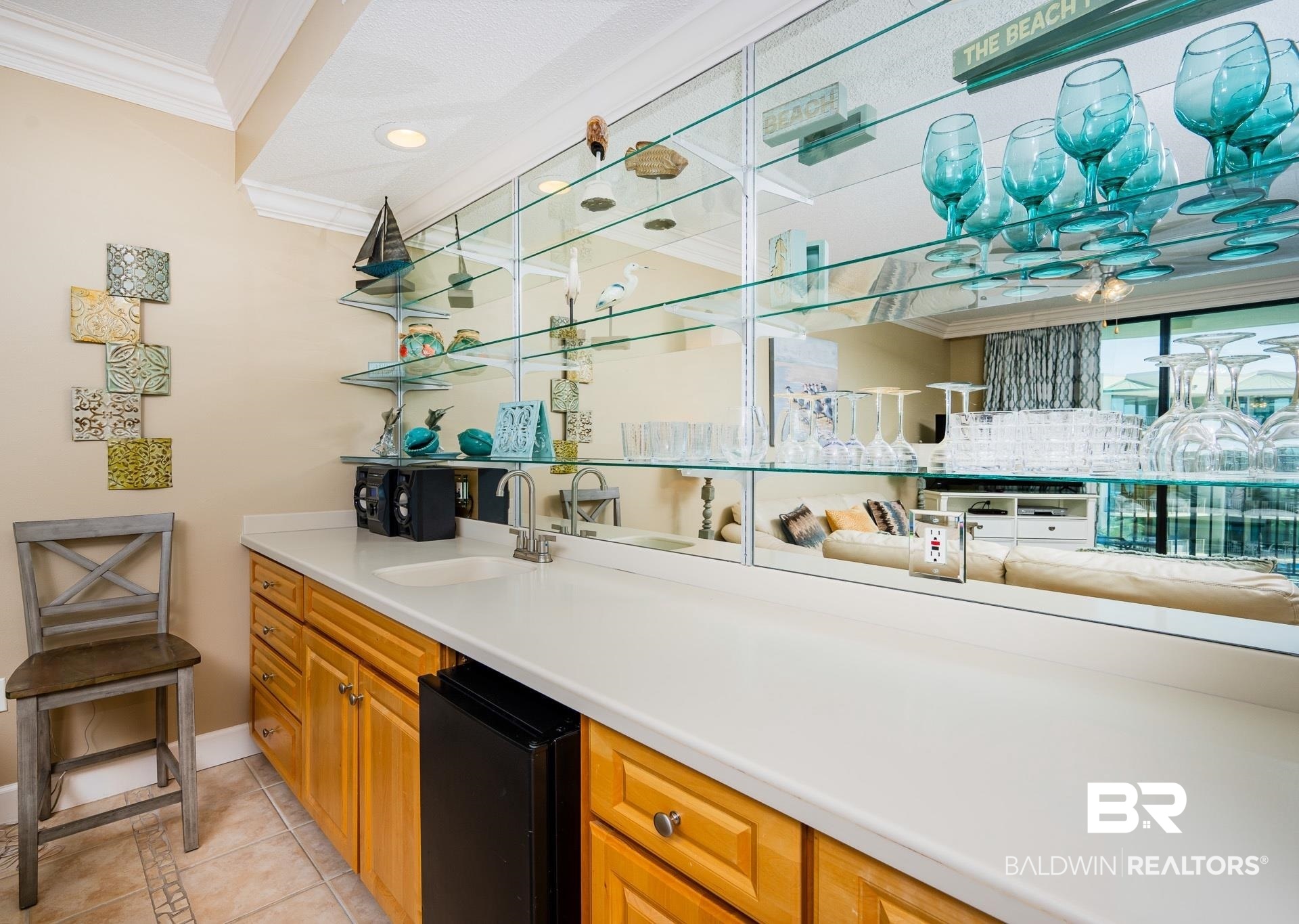 27580 Canal Road, Unit 1429 Orange Beach, AL 36561 - Photo 5 of 45 Bar area featuring open shelves, light tile patterned flooring, light countertops, black fridge, and ornamental molding