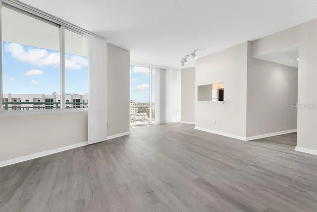 a view of a livingroom with wooden floor and a large window