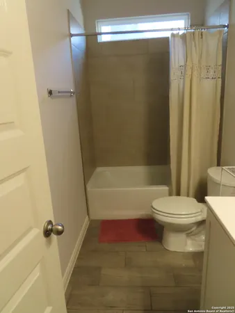 a bathroom with a toilet and a shower
