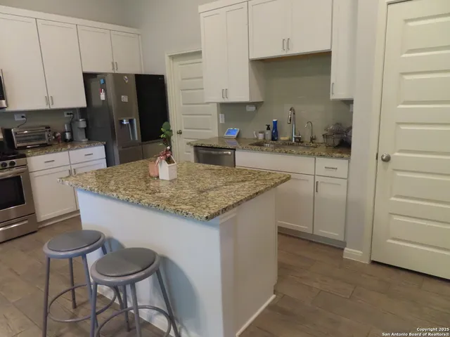 a kitchen with granite countertop sink cabinets and stainless steel appliances