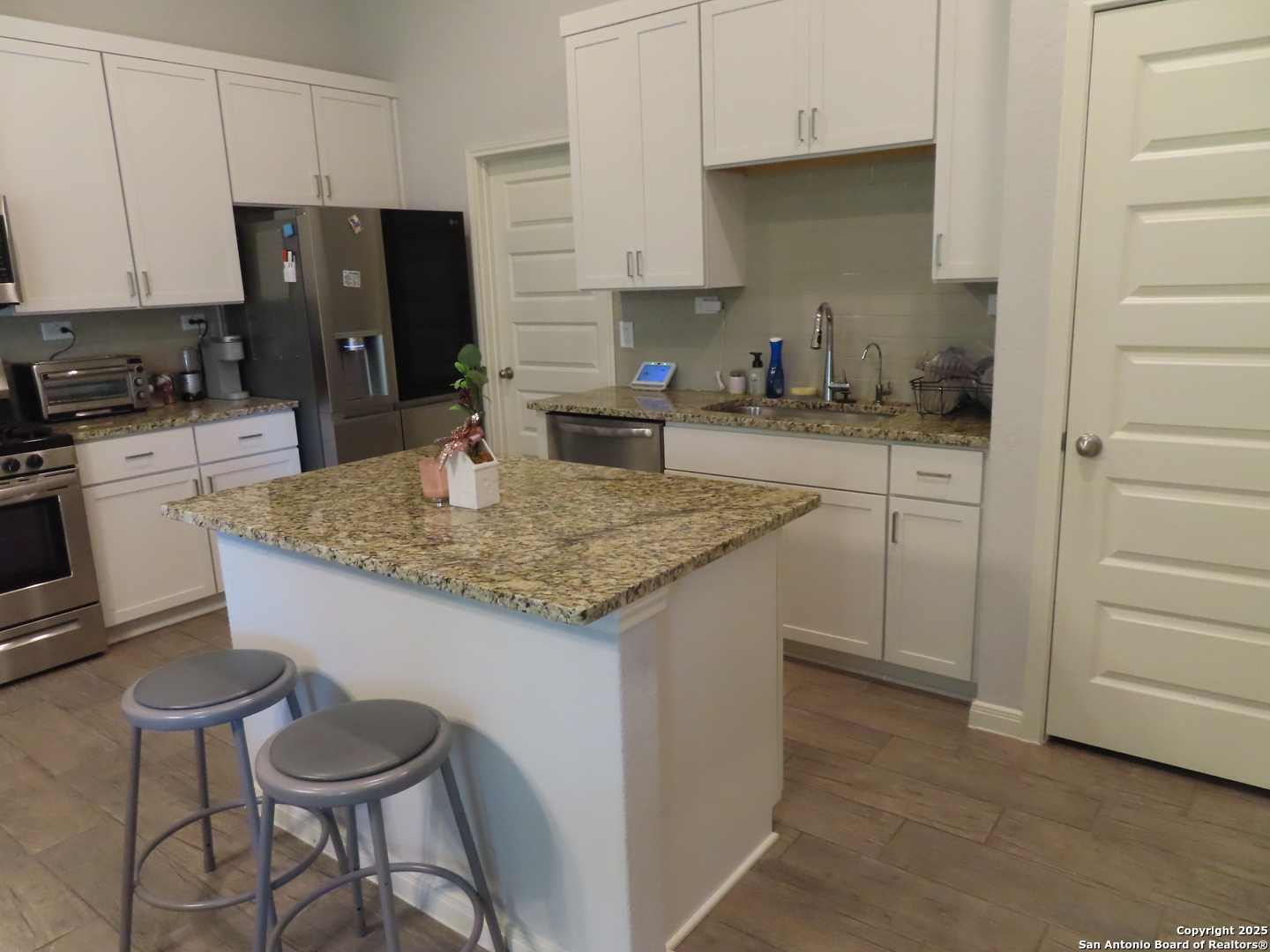 22150 Approach San Antonio, TX 78261 - Photo 8 of 18 a kitchen with granite countertop sink cabinets and stainless steel appliances