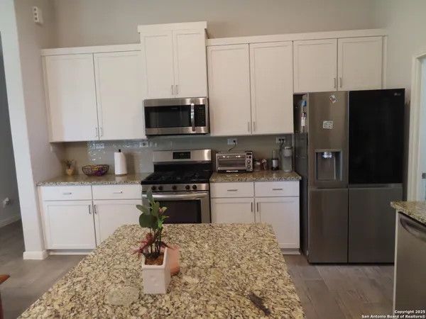 a kitchen with a refrigerator stove and white cabinets