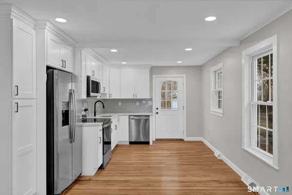 a kitchen with stainless steel appliances granite countertop a refrigerator and a stove top oven