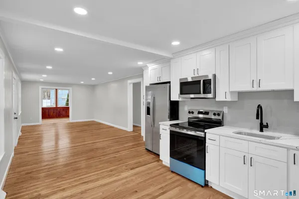 a kitchen with granite countertop white cabinets and stainless steel appliances