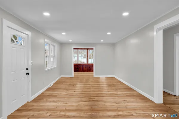 a view of empty room with wooden floor