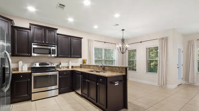 a kitchen with granite countertop stainless steel appliances sink and window