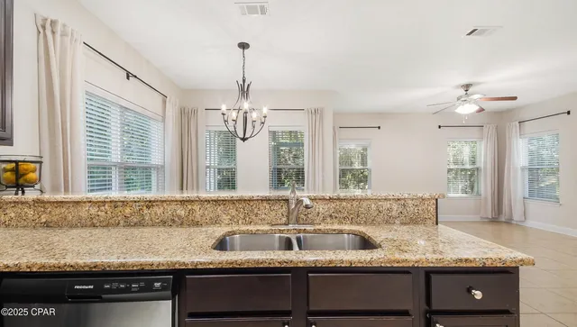 a kitchen with kitchen island granite countertop stainless steel appliances a sink a counter top cabinets and a window