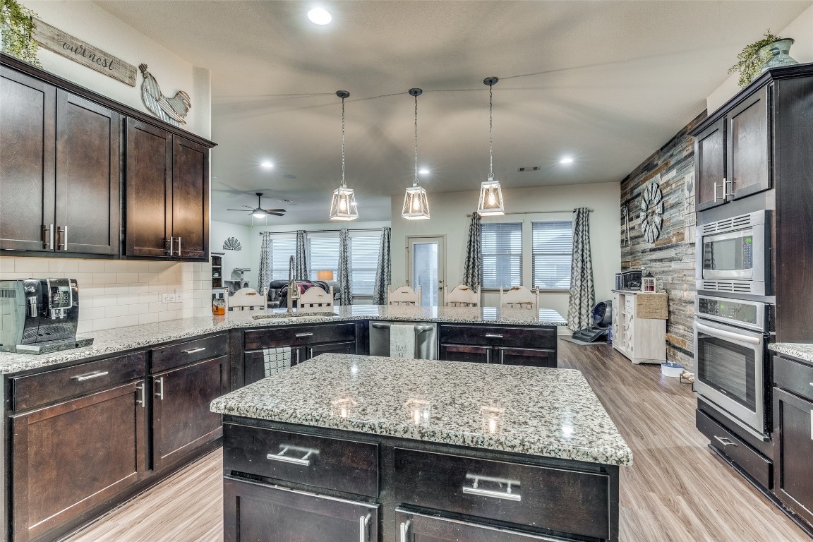 a kitchen with kitchen island granite countertop lots of counter top space and stainless steel appliances