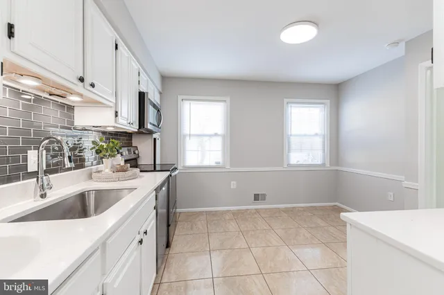 a bed sitting in a spacious bedroom next to a window