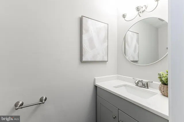 a bathroom with a sink vanity mirror and toilet