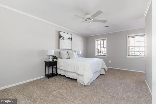 a bedroom with a large bed and chandelier
