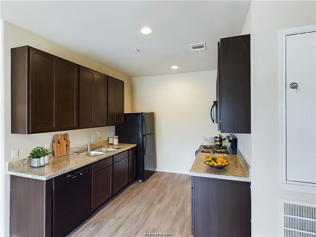 2910 Town Square Avenue, Unit 2114 Bryan, TX 77802 - Photo 4 of 8 a kitchen with a sink a stove and a refrigerator