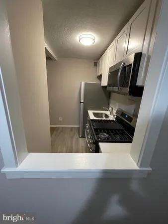 a view of kitchen with sink and refrigerator
