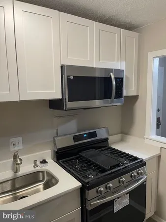 a kitchen with granite countertop a stove and a microwave