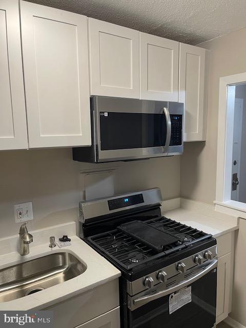 1836 Metzerott Road, Unit 1516 Hyattsville, MD 20783 - Photo 18 of 26 a kitchen with granite countertop a stove and a microwave