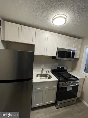 a kitchen with stainless steel appliances a refrigerator stove and microwave