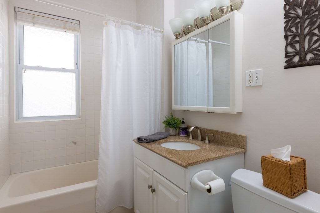 42 Stanton Road, Unit 1 Brookline, MA 02445 - Photo 11 of 16 a bathroom with a granite countertop sink and a mirror