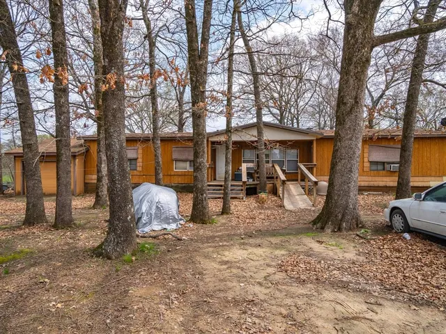 a backyard of a house with barbeque oven table and chairs