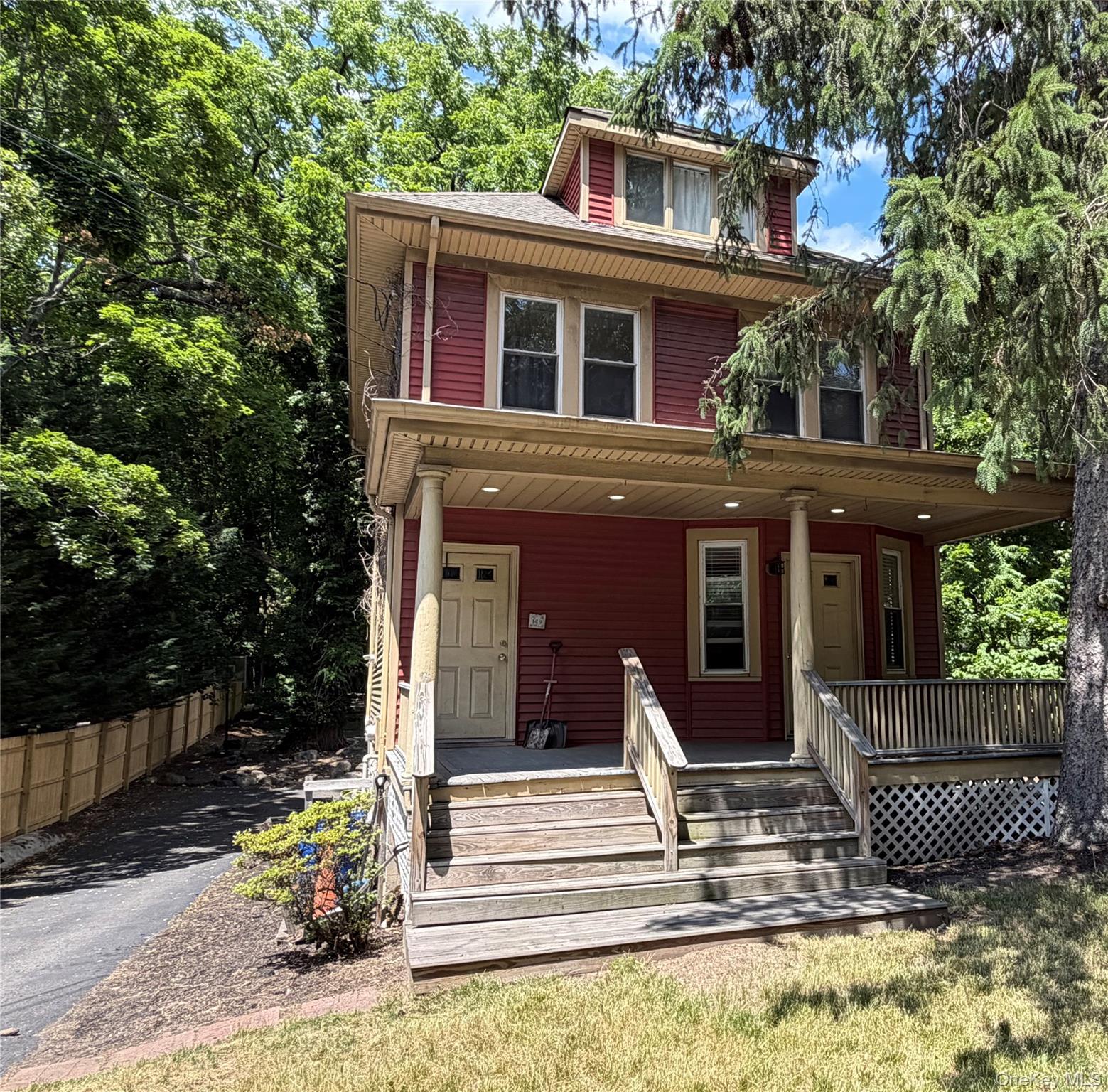 149 Fort Salonga Road Northport, NY 11768 - Photo 19 of 23 Red siding exterior featuring a covered porch, white trim, and a dormer window