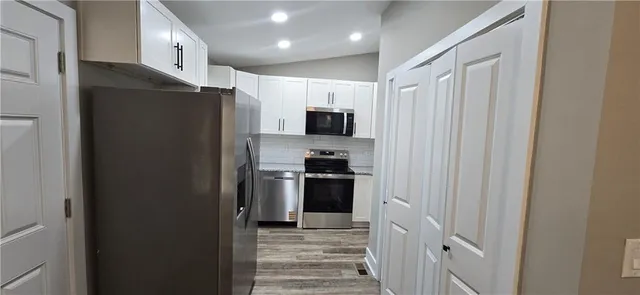 a kitchen with stainless steel appliances granite countertop a refrigerator and a stove top oven