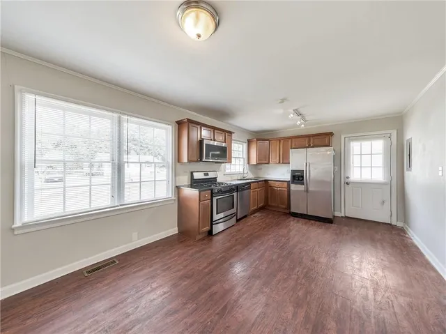 a large kitchen with a wooden floor and white appliances