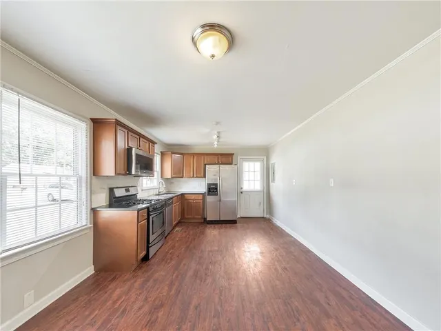 a kitchen with stainless steel appliances granite countertop a stove top oven a sink and a refrigerator