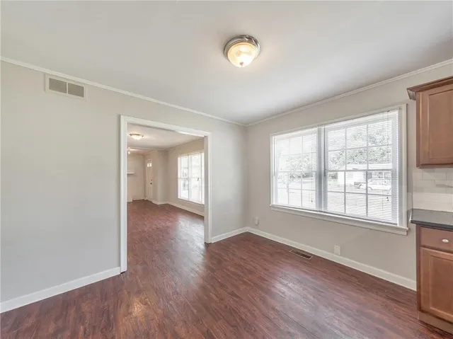 a view of empty room with wooden floor and fireplace