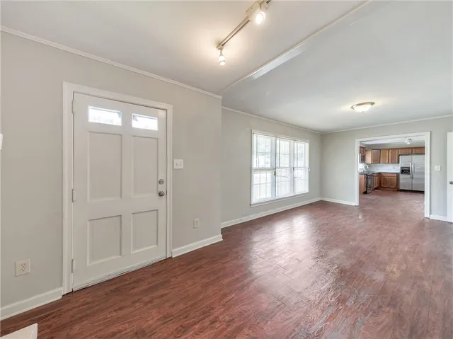 a view of empty room with wooden floor