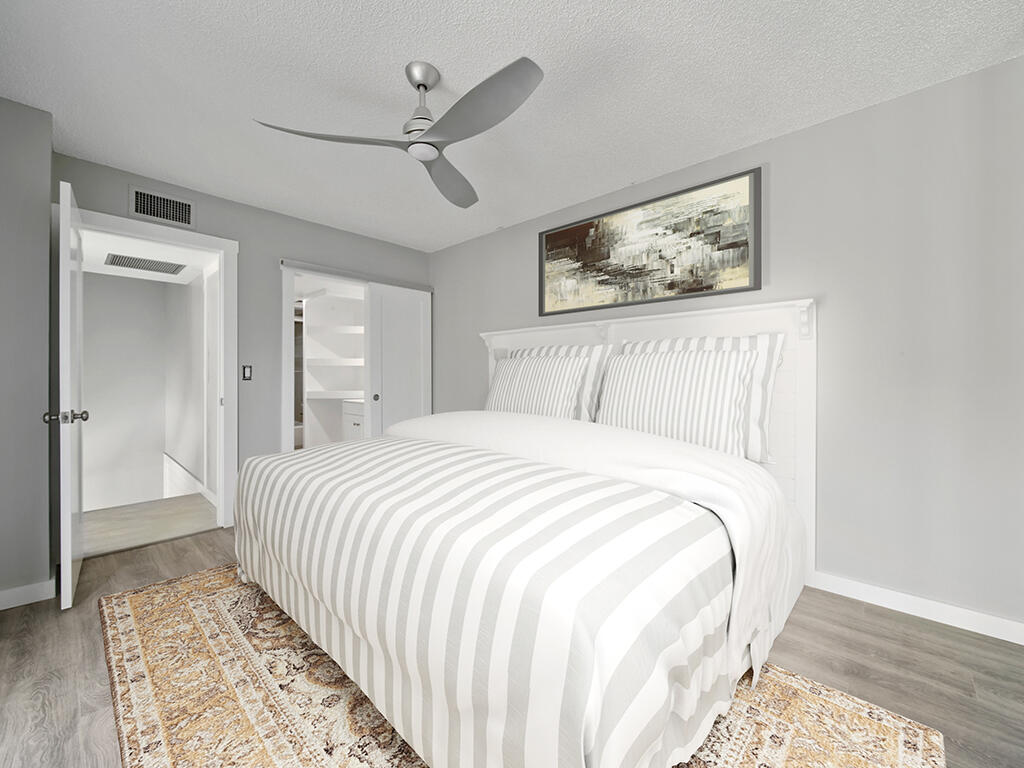 5992 Southeast Riverboat Drive, Unit 537 Stuart, FL 34997 - Photo 12 of 14 a bedroom with a large bed and a chandelier
