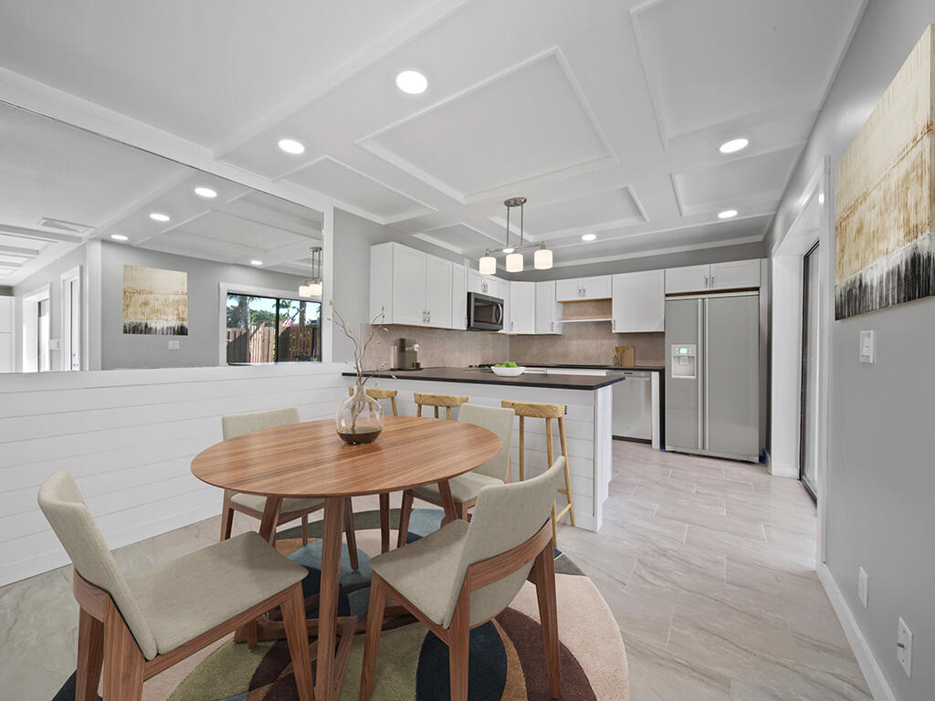 5992 Southeast Riverboat Drive, Unit 537 Stuart, FL 34997 - Photo 3 of 14 a kitchen with a dining table chairs stainless steel appliances and cabinets