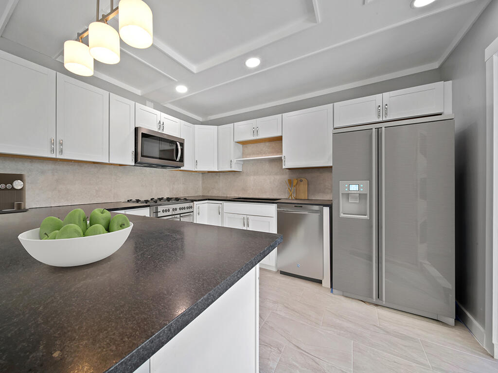 5992 Southeast Riverboat Drive, Unit 537 Stuart, FL 34997 - Photo 5 of 14 a kitchen with stainless steel appliances granite countertop a refrigerator a stove a sink dishwasher and white cabinets with wooden floor