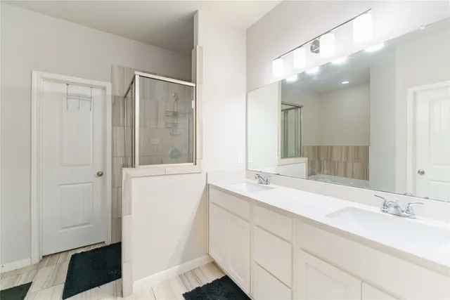 a bathroom with a double vanity sink and mirror