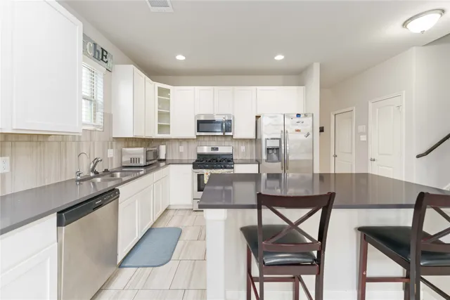 a kitchen with a dining table chairs and refrigerator