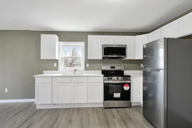 a large kitchen with a refrigerator and a stove top oven