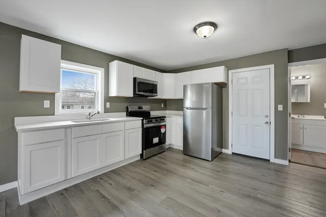 a view of a kitchen with a sink and a refrigerator