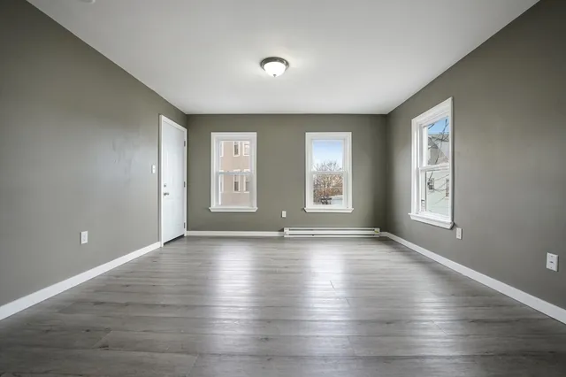 a view of a kitchen counter space wooden floor cabinet and windows