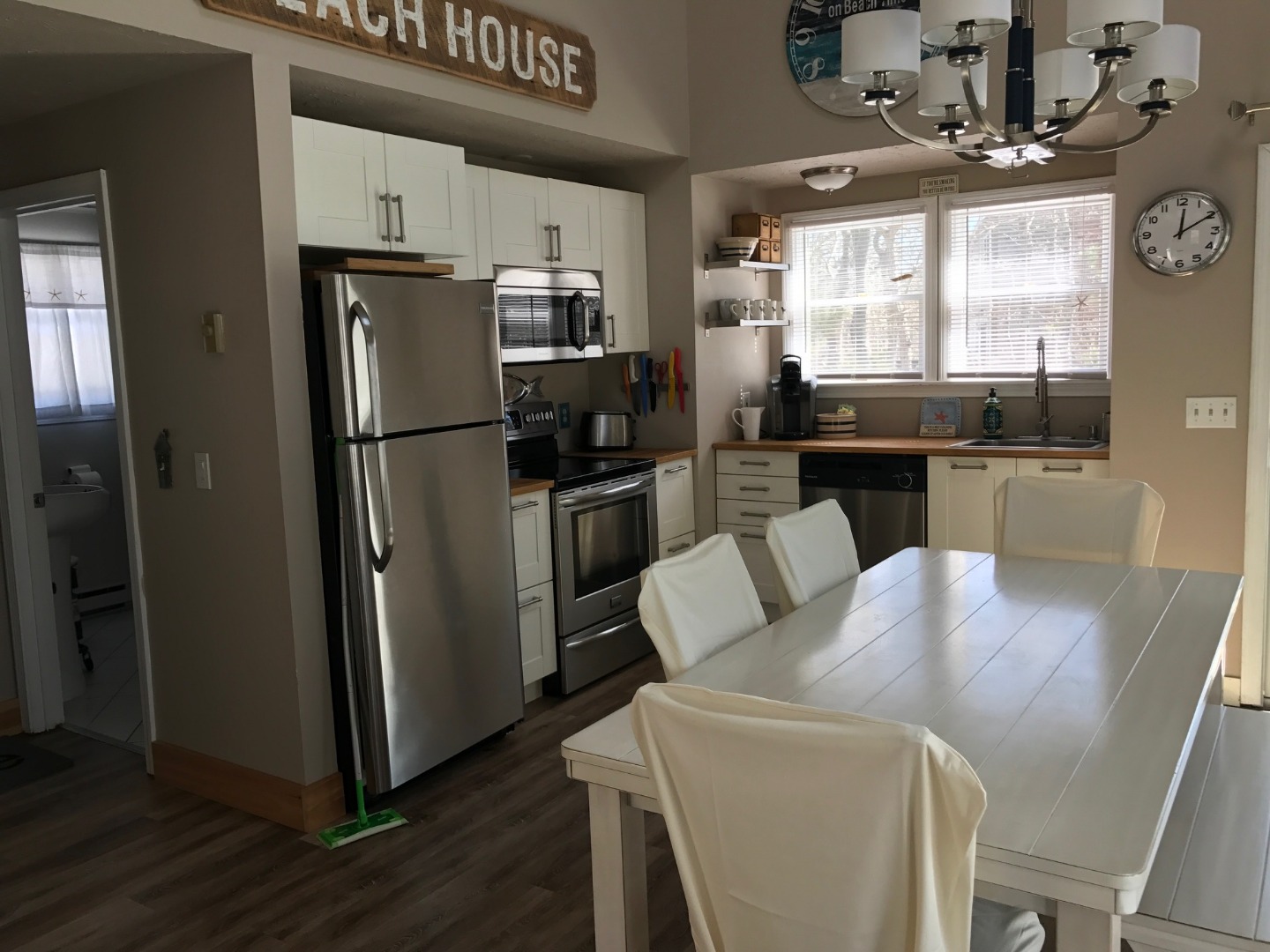 95 Whalers Walk Edgartown, MA 02539 - Photo 22 of 33 a kitchen with a refrigerator a stove a sink and a dining table with wooden floor