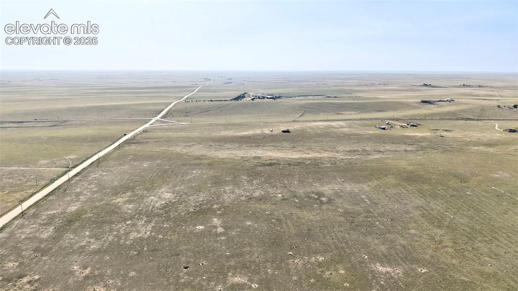 9670 Boone Road Yoder, CO 80864 - Photo 4 of 18 Expansive land parcel featuring a long, straight road, distant structures, and open terrain